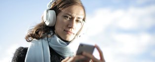 Frau mit Kopfhörern und Smartphone